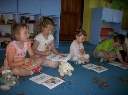 dziewczynki czytają siedząc na dywanie