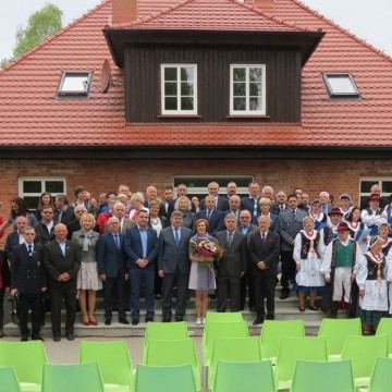 grupa ludzi pozująca razem do zdjęcia przed Centrum Edukacji i Promocji w Łupawsku