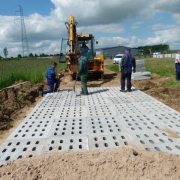 robotnicy wraz z koparką podczas budowy drogi na terenie Wielofunkcyjnego Ośrodka Przemysłowo – Usługowego w Potęgowie