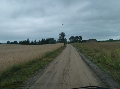 droga o nawierzchni piaszczystej obok pola