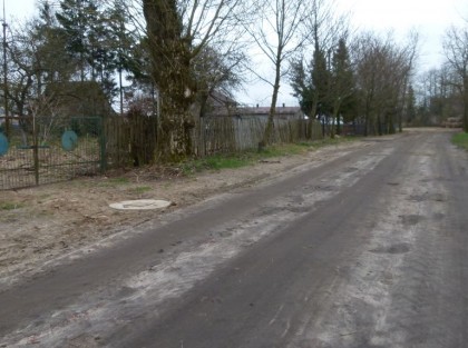 Zdjęcie przebudowanej drogi, na pierwszym planie widać właz sieci kanalizacyjnej