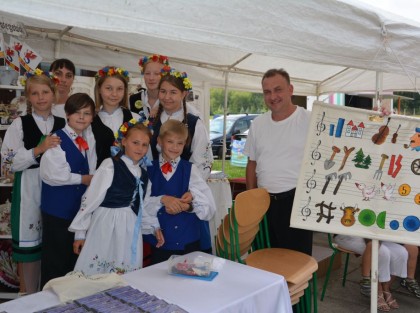 dorośli i dzieci przebrani w regionalne stroje pozują do zdjęcia