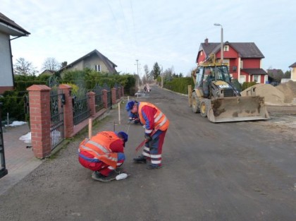 Ulica Pocztowa przed przebudową, na pierwszym planie pracownicy w tle koparka