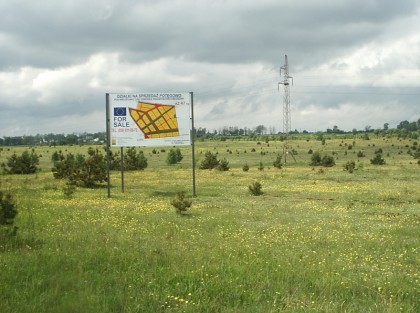 Reklama terenów inwestycyjnych stojąca na polu