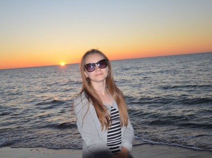 nastolatka w okularach przeciwsłonecznych pozuje na tle morza